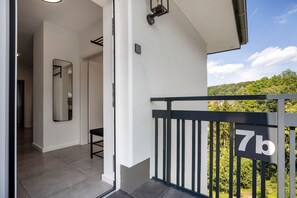 En balkon med gelænder i sort og et skilt med teksten '7b'.