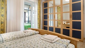 Un dormitorio con cama, armario y vistas al exterior.