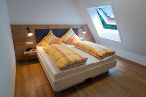 A bedroom with a wooden headboard, a skylight, and a bedside table with a lamp. - Apartment 'Ferienwohnung Holunder' with Mountain View, Shared Terrace and Wi-Fi (Gengenbach)