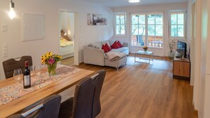Ett modernt vardagsrum med en matplats, en soffa och ett TV-bord.