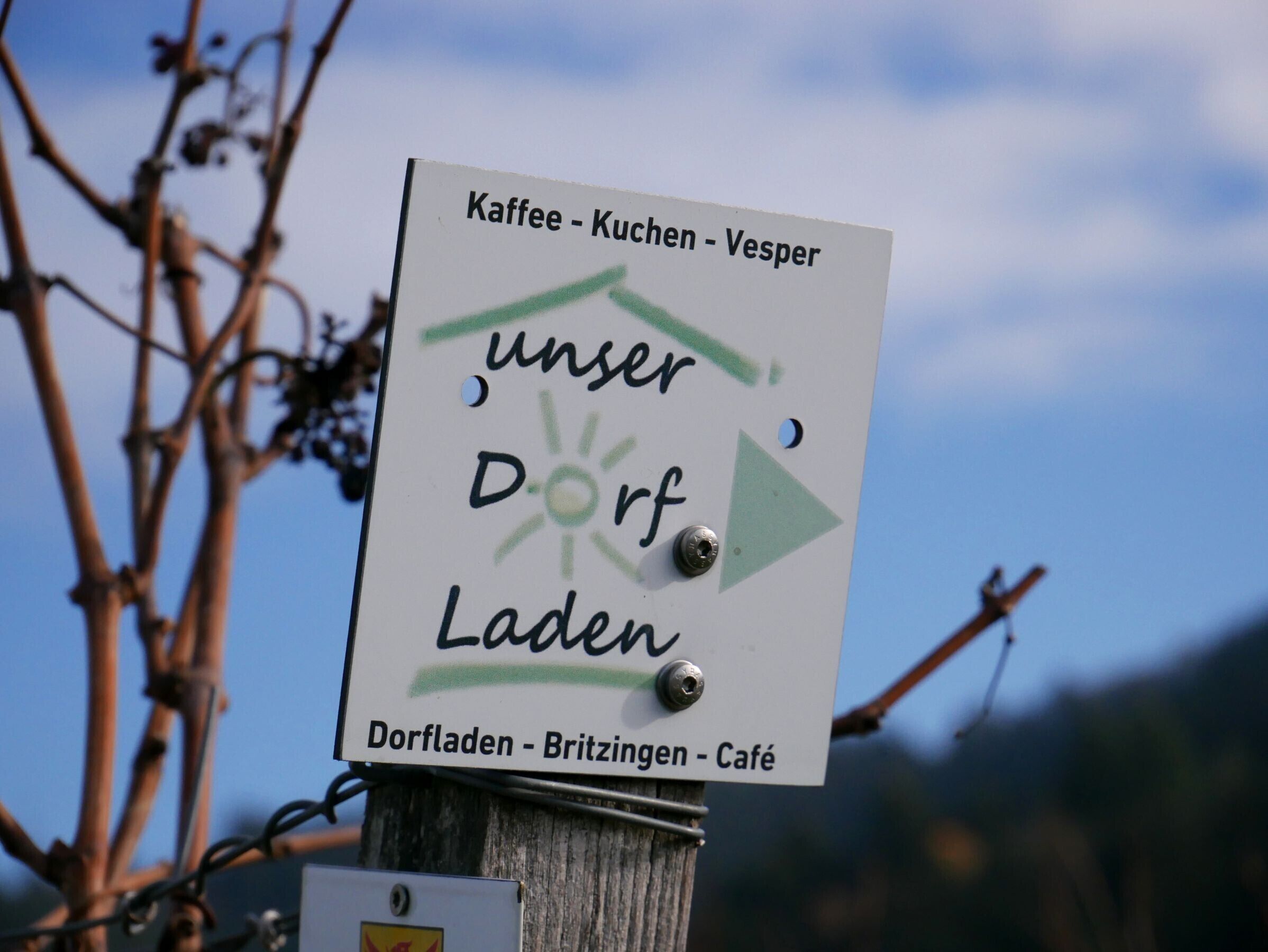 A directional sign with text indicating locations and a symbol for a sun.