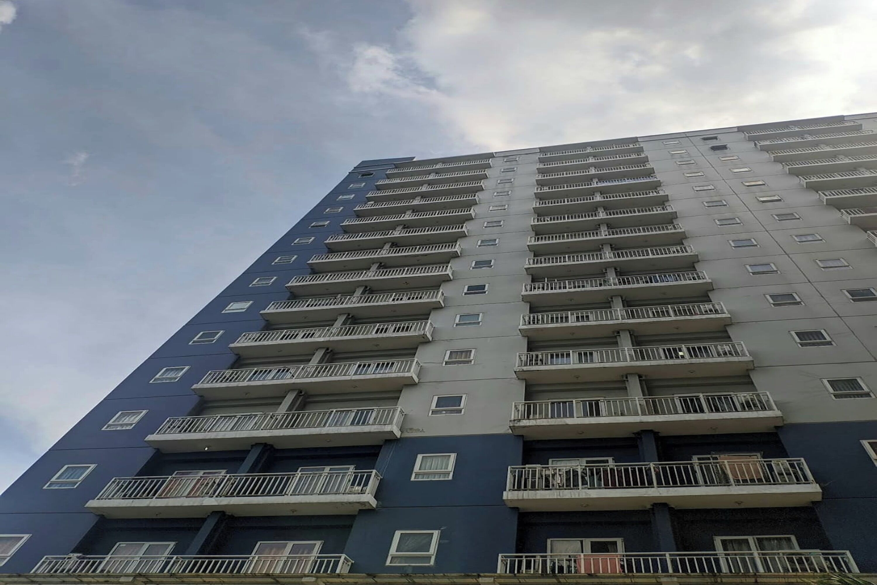 A high-rise building with multiple balconies and windows.