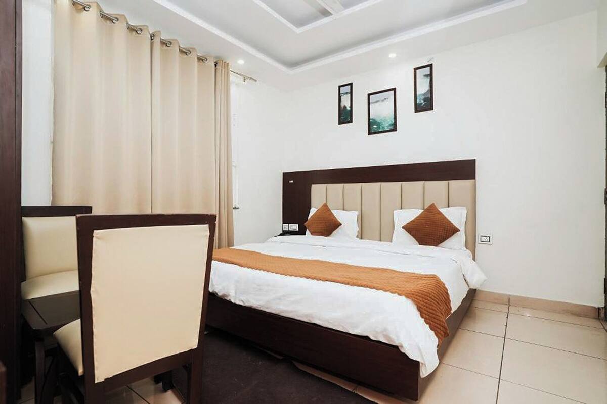 A hotel room with a bed, a chair, and a desk.