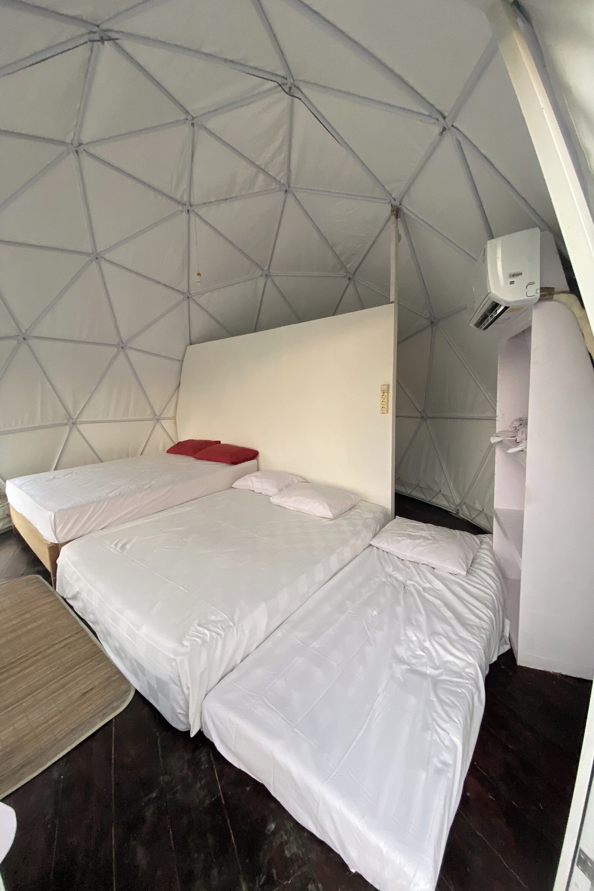 Una habitación tipo tienda con dos camas, un calentador y una mesita.