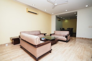 Relax in this stylish living room with two sofas, a coffee table, and a ceiling fan.
