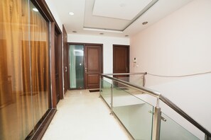 Experience the hotel's clean, minimalist design with a clear view of adjacent rooms from the glass railing.