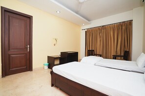 A hotel room with two beds, a wooden door, a desk, a chair, and a curtain. - Home 92 (Noida)