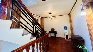 Una escalera con barandillas de madera y un candelabro.