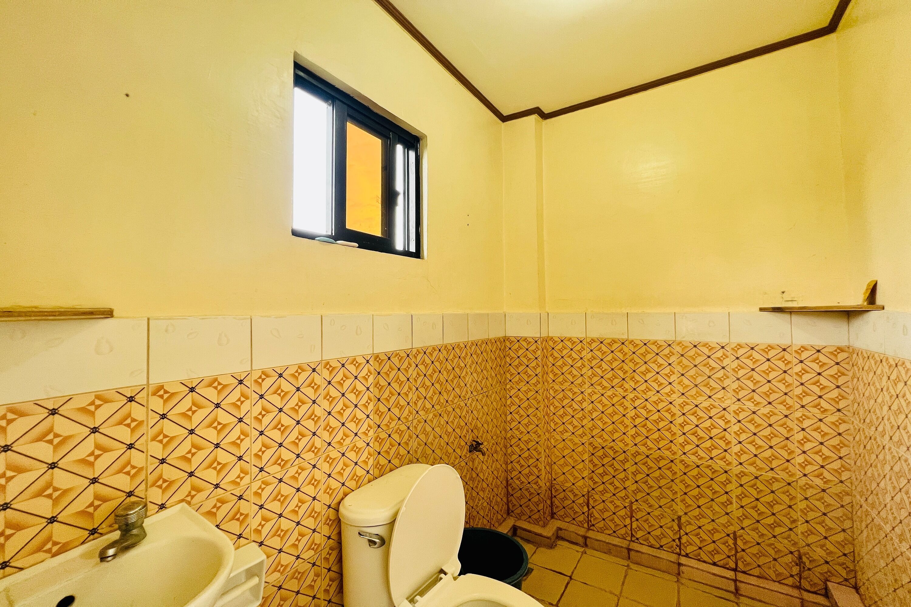 Un baño con inodoro, lavabo y ventana.