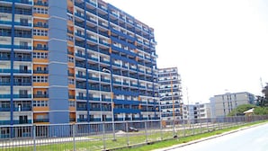A multi-story residential building with a blue and orange facade, featuring balconies and a central courtyard. - Deluxe Apartment (Lagos)