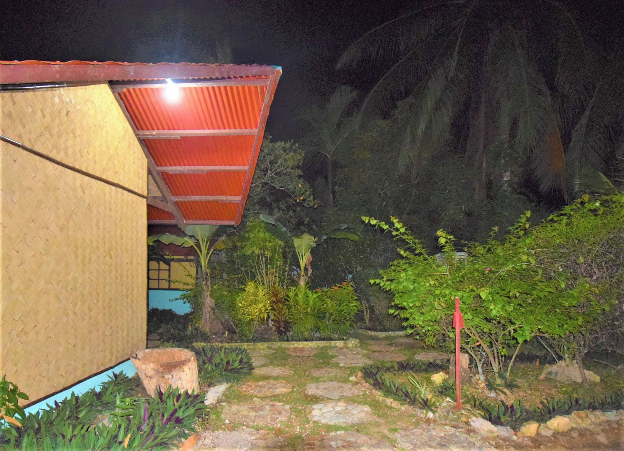 A building with a corrugated metal roof and a bamboo wall.