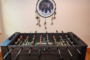 A foosball table with a dreamcatcher above it.