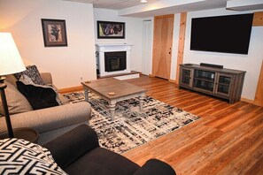 A living room with a fireplace, a television, and a sofa.