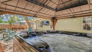 A hot tub area with seating and a TV screen.