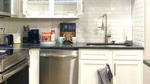 A modern kitchen with white cabinets, a stainless steel dishwasher, a microwave, and a coffee maker. - SUAVE&SPACIOUS SUITE NEAR EVERYTHING (Atlanta)