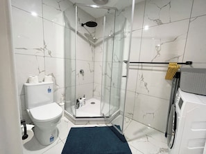 A modern bathroom with a glass-enclosed shower, a toilet, and a sink. - Mentone Compact Backyard Cabin Beachside (Parkdale)