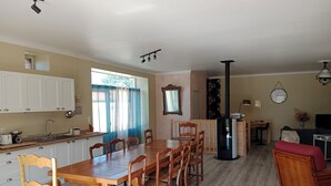 Eine geräumige Küche mit Essbereich, Holzschränken, einer Spüle und einem Kühlschrank.