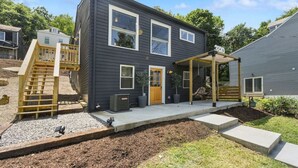 A two-story house with a covered porch, a wooden staircase, and a front door. - ★ HostWise Stays ★ 2 Apartments in 1 - Great Privacy, Beautiful Space! (Pittsburgh)
