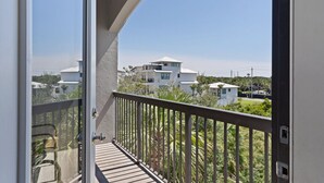Un balcon donnant sur des maisons modernes et un ciel dégagé.