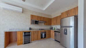 A modern kitchen with wooden cabinets, stainless steel appliances, and a granite countertop.