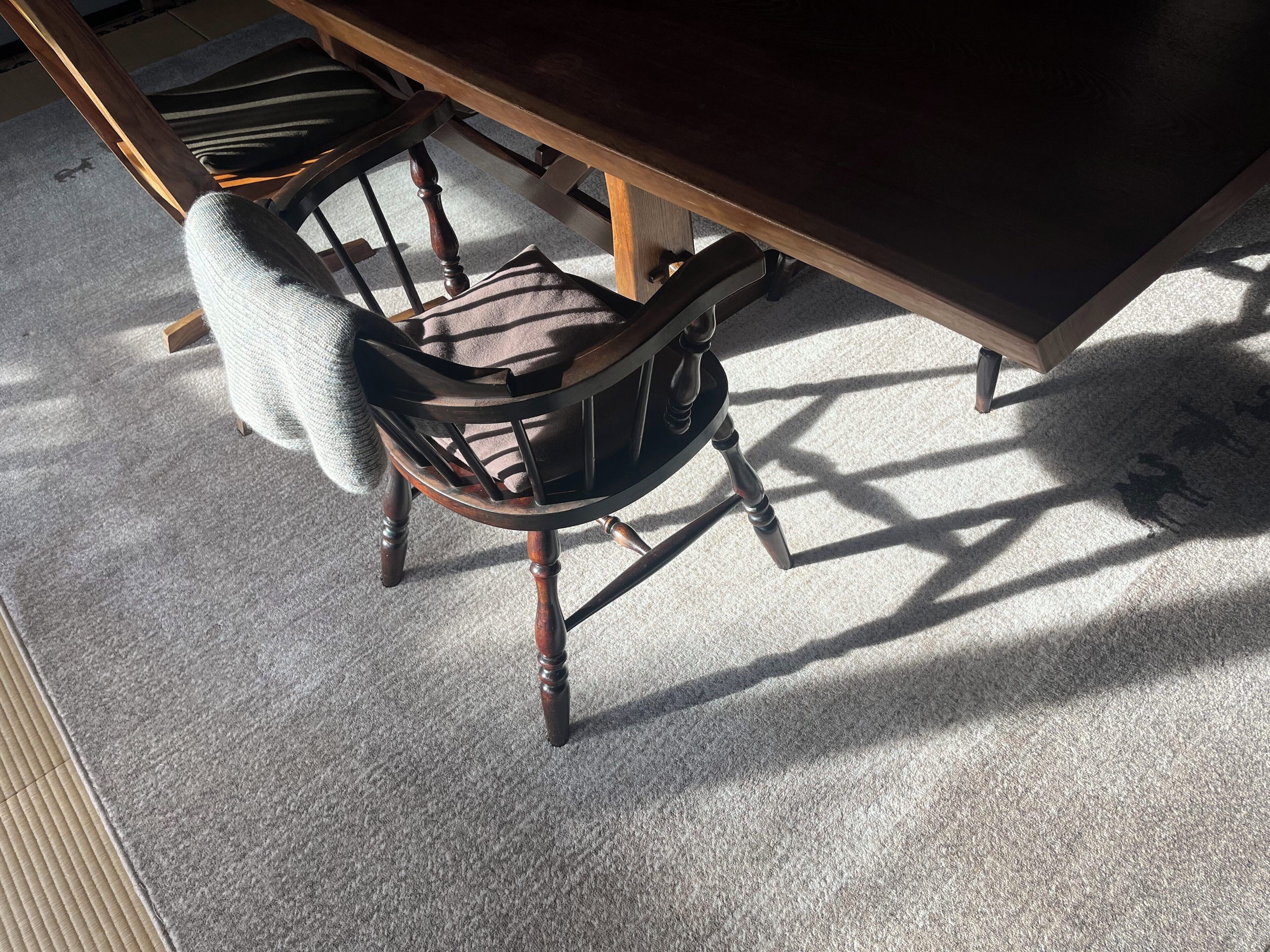 A wooden dining table with chairs underneath.