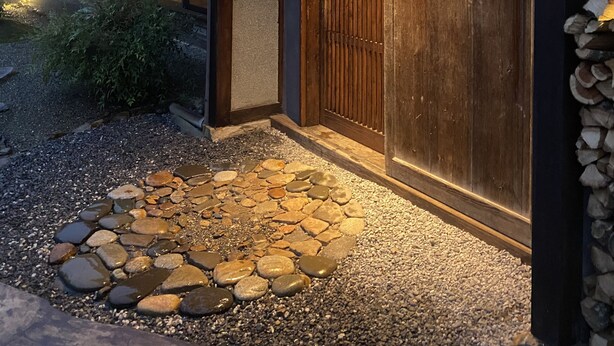A traditional Japanese building with a wooden entrance, a tiled roof, and a stone pathway leading to the door. - Ryokan Tsuchi to Ito (Omi)