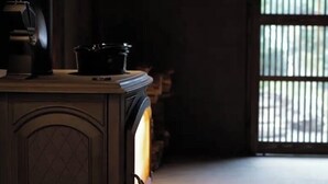 A room with a wooden cabinet and a stove. - Ryokan Tsuchi to Ito (Omi)