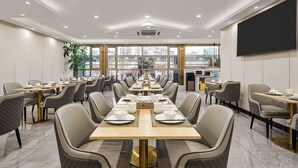 A conference room with long tables, chairs, a large window, and a flat-screen TV. - YISHANG HOTEL (Guangzhou)