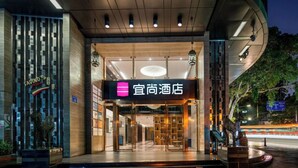 A hotel entrance with a modern design, featuring a prominent sign and a glass door. - YISHANG HOTEL (Guangzhou)