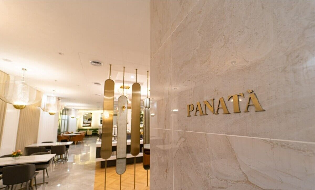 Un interior moderno con una pared de mármol que muestra el nombre "PANATA".
