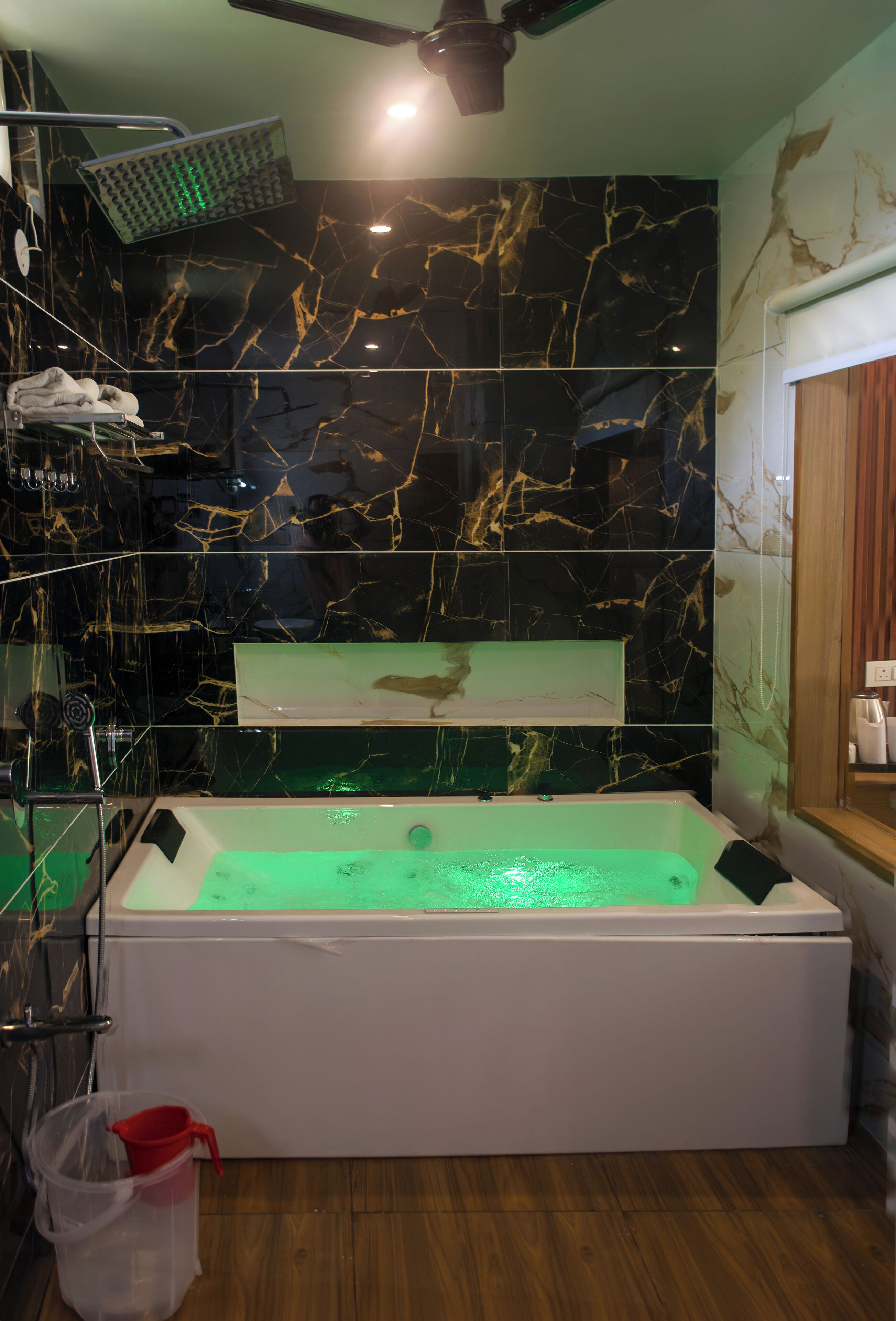 A modern bathroom with a freestanding bathtub, a glass shower enclosure, and marble walls.