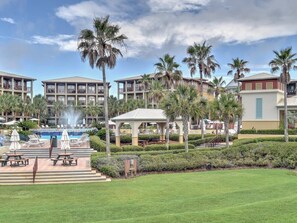 A resort with a swimming pool, palm trees, and a gazebo.
