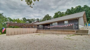 Ein Gebäude mit überdachter Veranda, einem Schotterweg und einer amerikanischen Flagge.