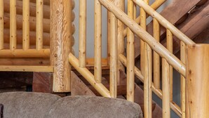 Un escalier en bois menant à l’intérieur d’une cabane en rondins.