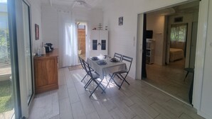 Un comedor con una mesa dispuesta para cuatro, un ventilador de techo y vistas al exterior.