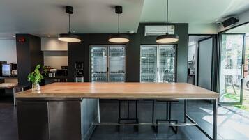 A modern kitchen with a large island, stainless steel appliances, and pendant lighting.