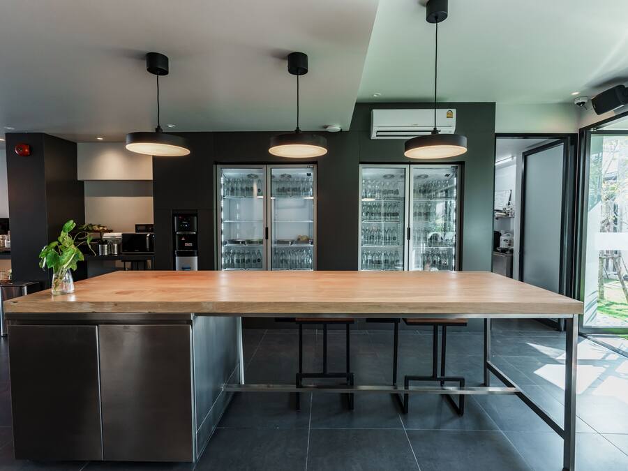 A modern kitchen with a large island, stainless steel appliances, and pendant lighting.