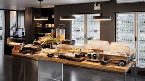 A buffet setup with various food items and a water refill station. - POR Arak (Chiang Mai)