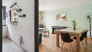 Una cocina moderna con comedor, un piano y un ventilador.