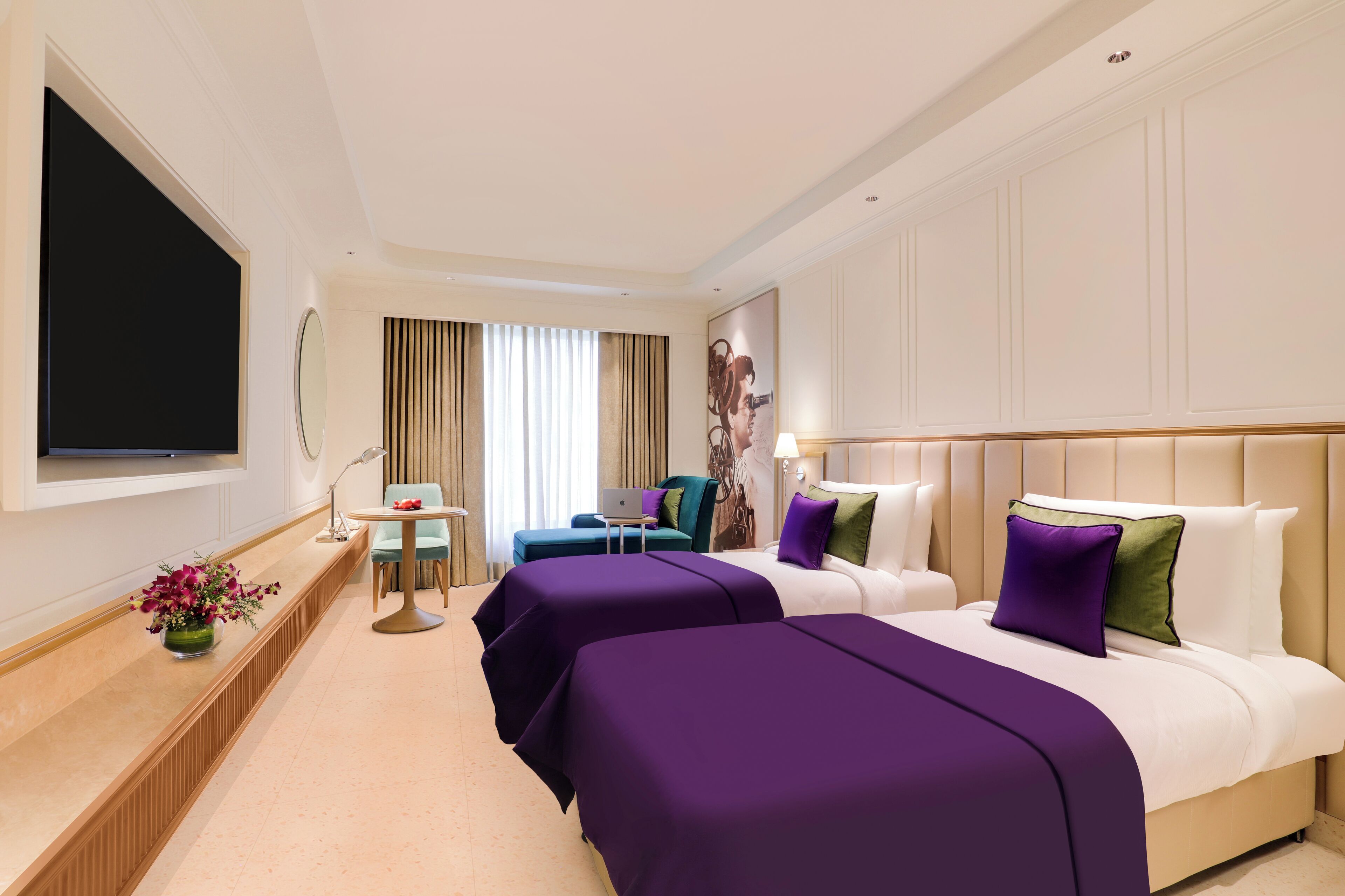 Habitación de hotel con dos camas, televisión, escritorio y ventana con cortinas.