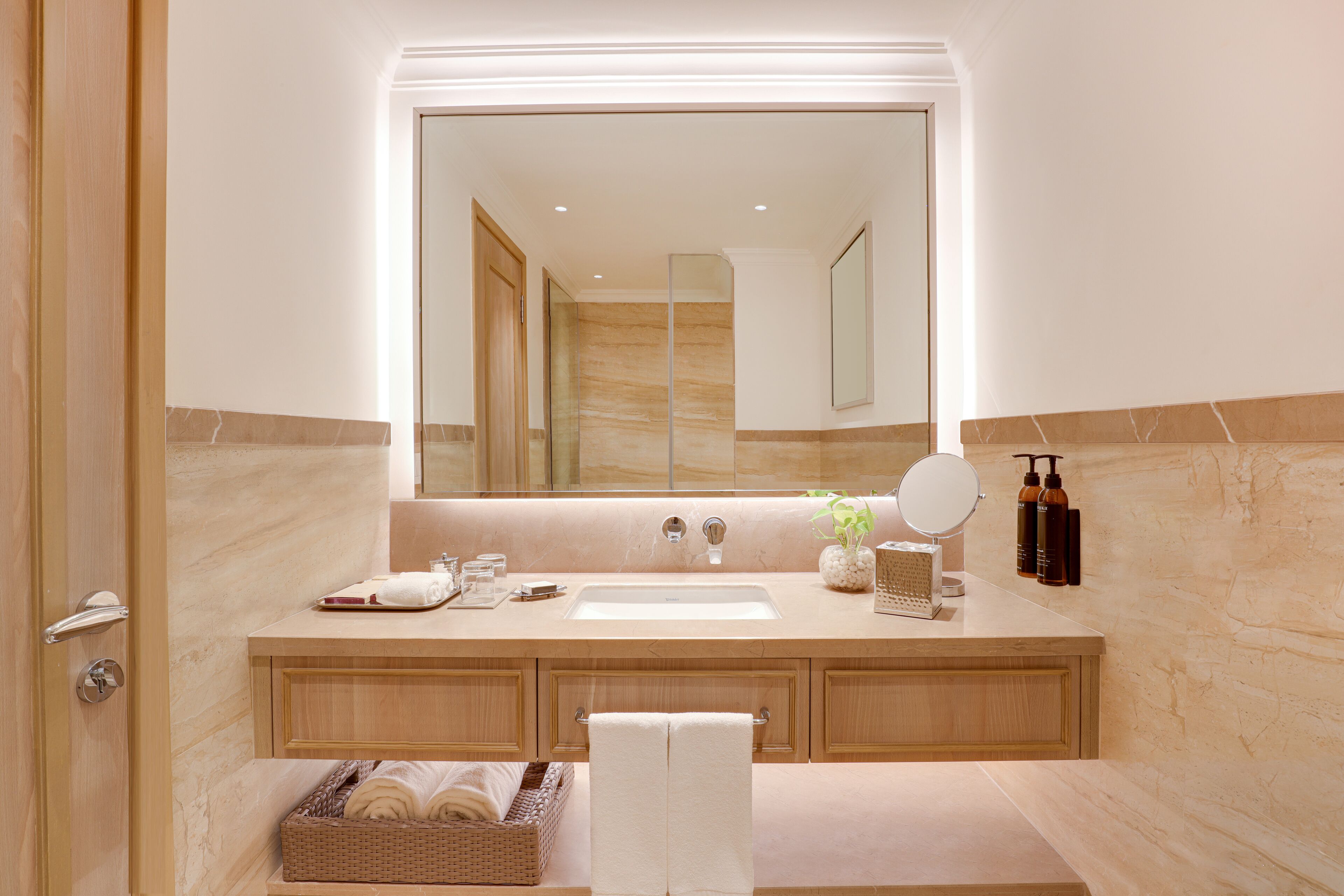 Un baño moderno con un espejo grande, un lavabo y un mueble de tocador.