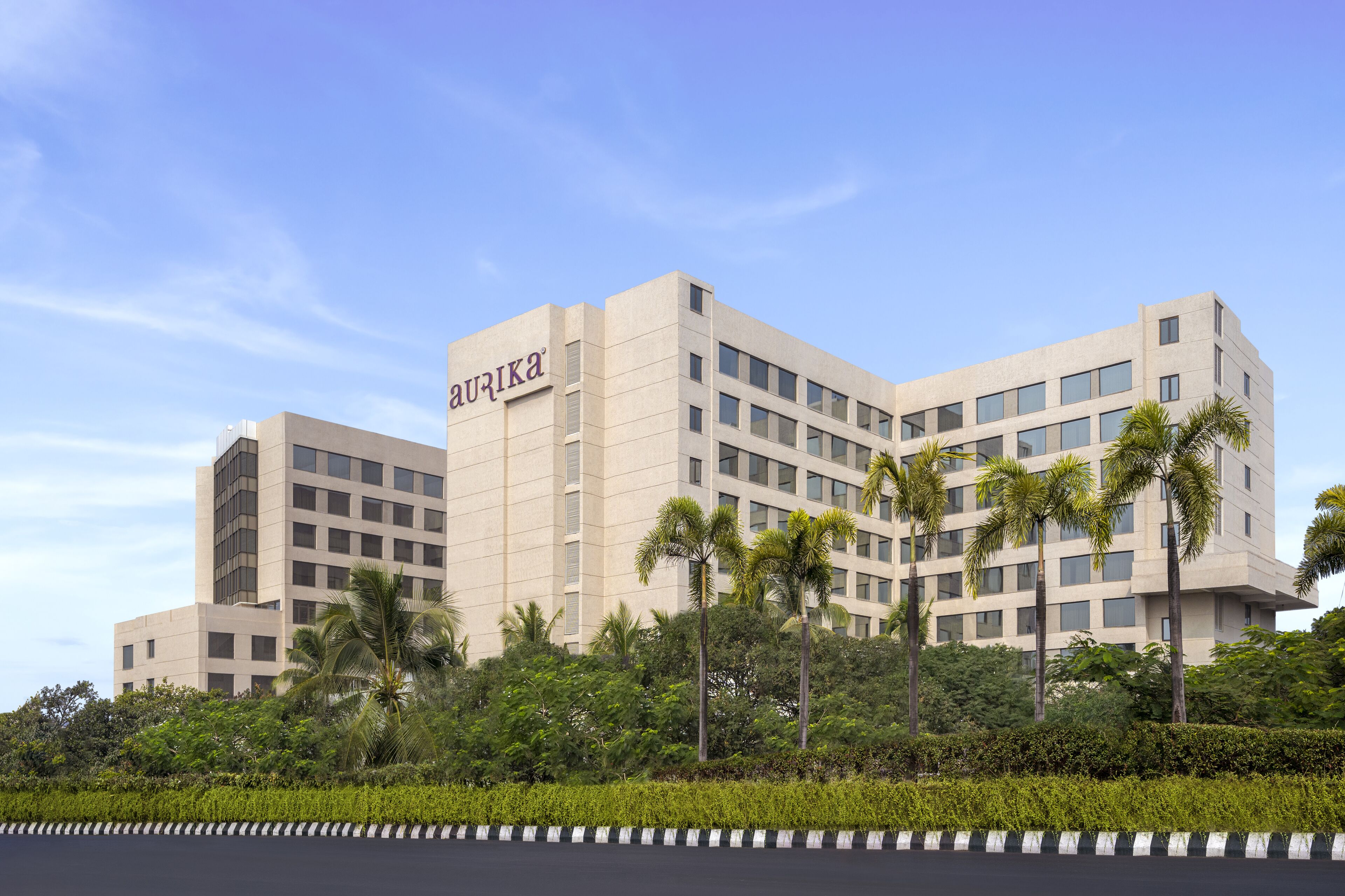A modern hotel with a flat facade, multiple floors, and a sign reading "aurika".