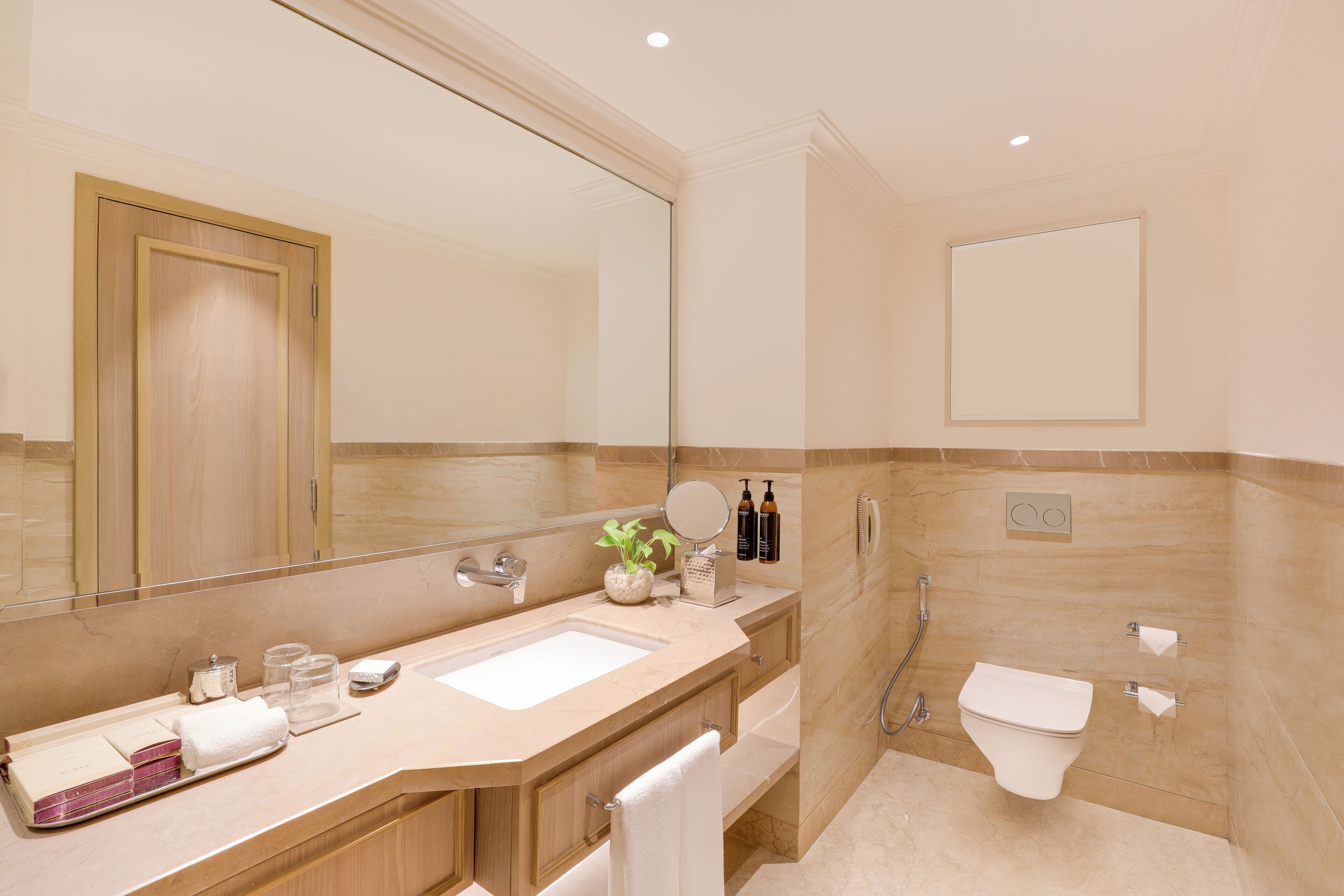 A modern bathroom with a large mirror, a sink, and a shower.