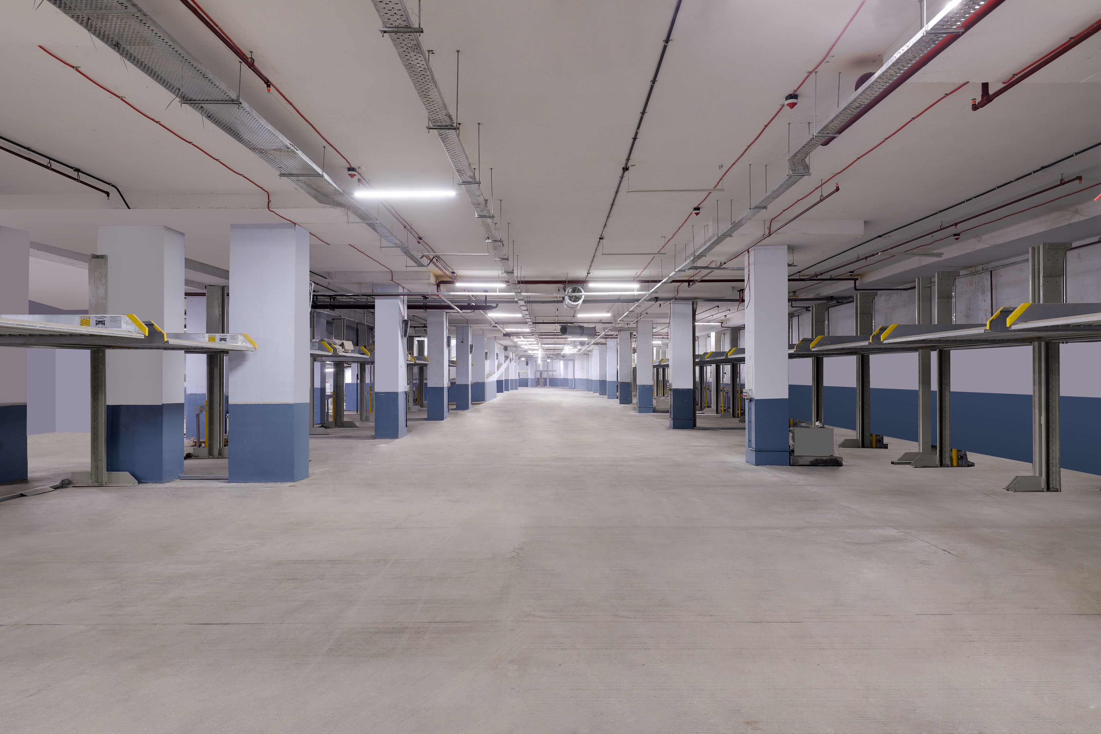 A spacious parking garage with multiple levels, concrete floors, and structural columns.