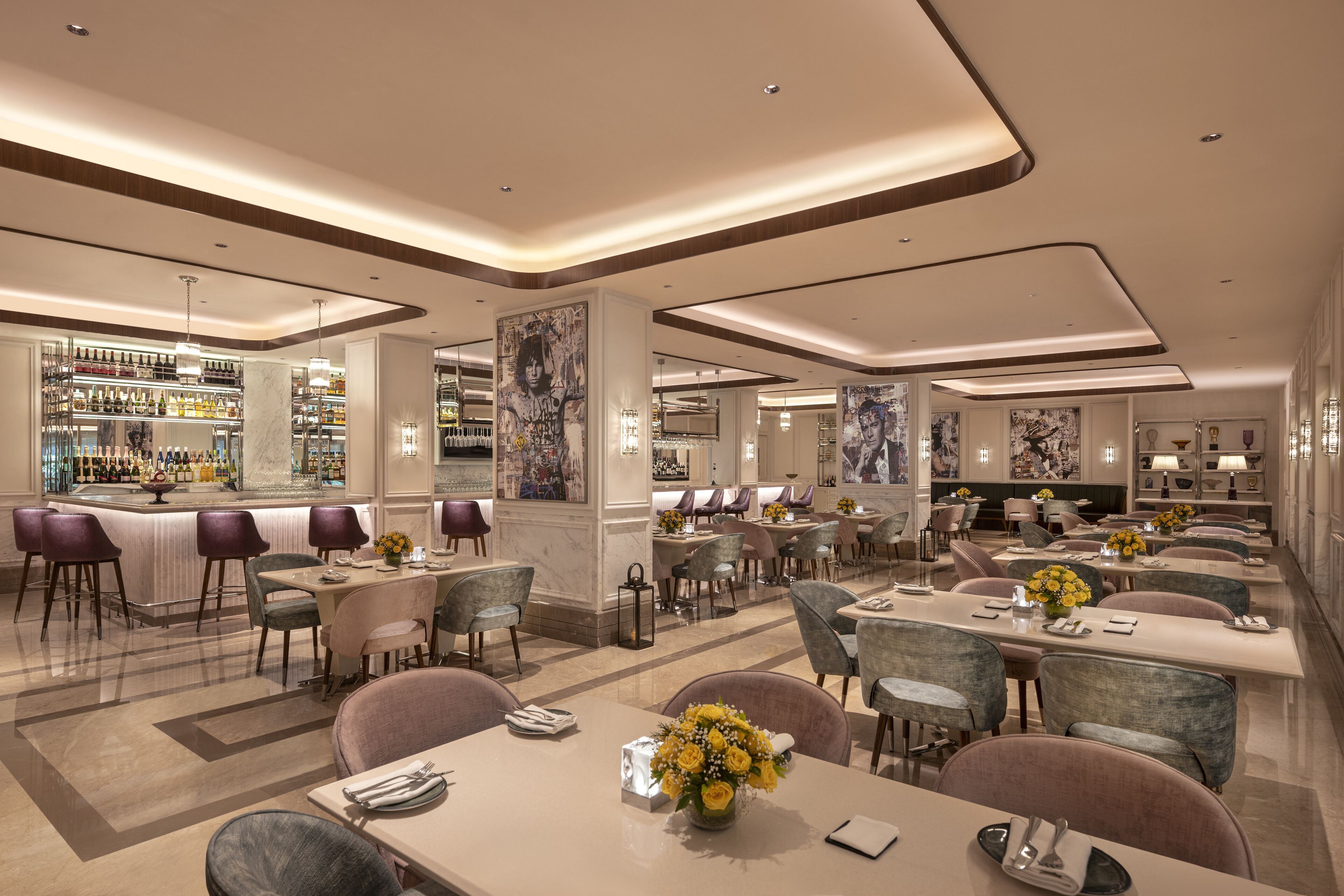 A modern hotel lobby with a bar, dining area, and seating.