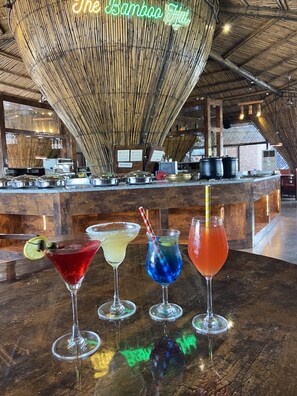A bar area with a bamboo ceiling and a neon sign reading "The Bamboo Hut". - DAN Resorts & Weddings (Dahanu)