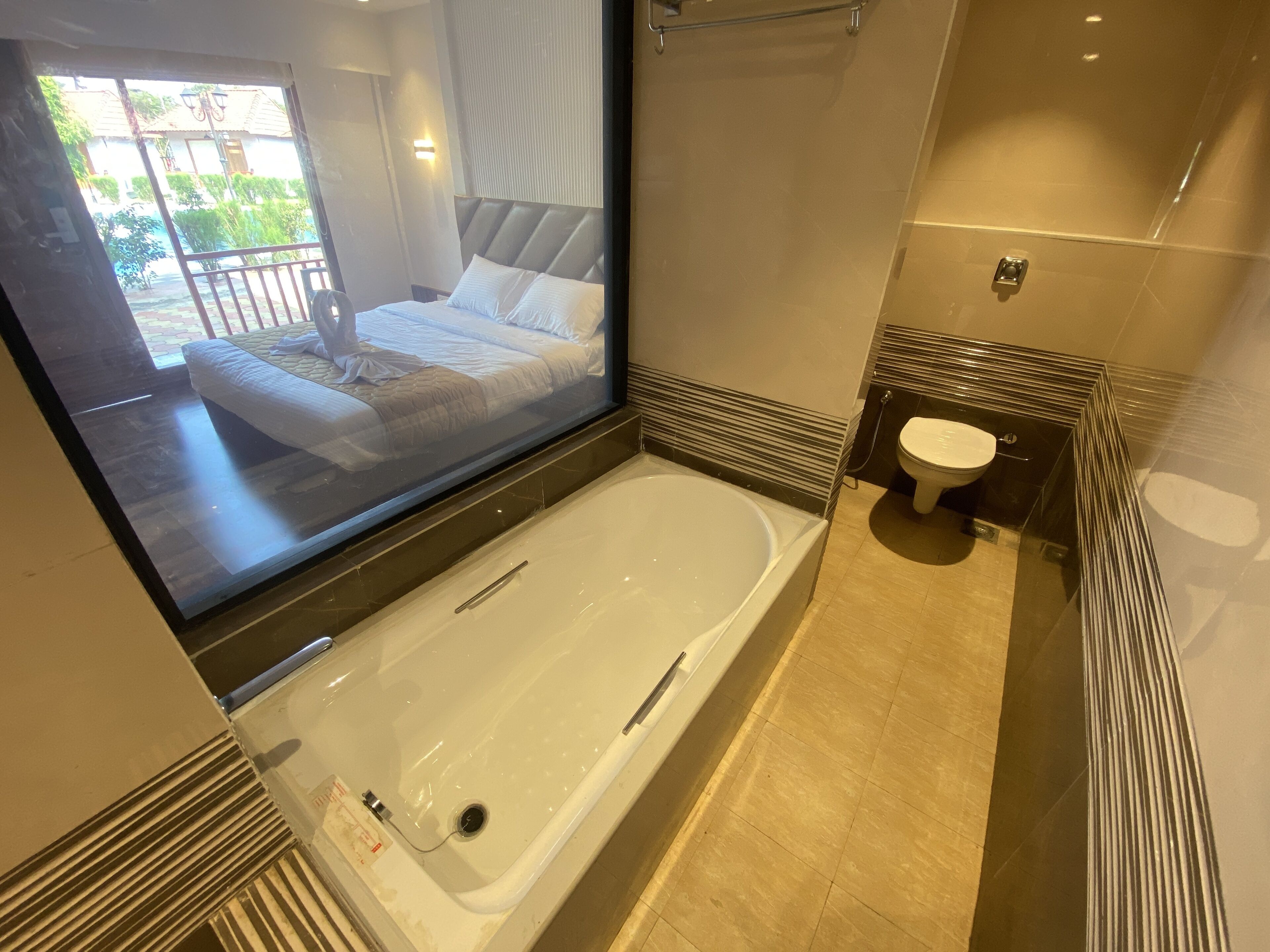 A modern bathroom with a large bathtub, a toilet, and a shower area.