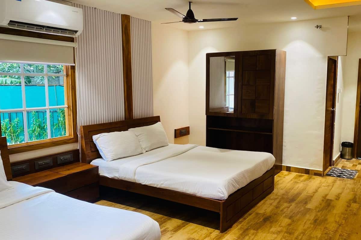 A bedroom with a wooden bed, a ceiling fan, a window with blinds, and a view of greenery outside.