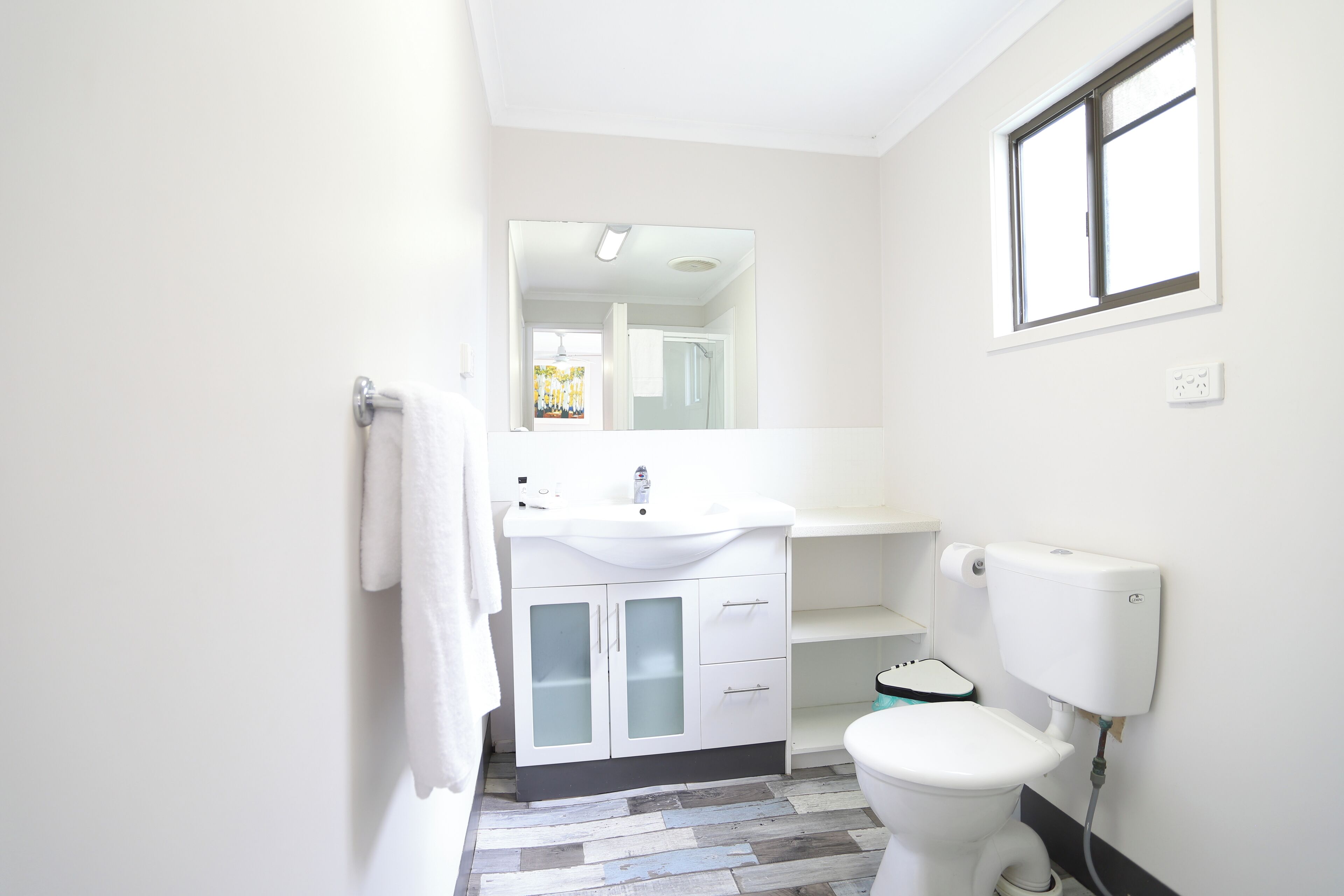 A bathroom with a white sink, a toilet, and a shower.