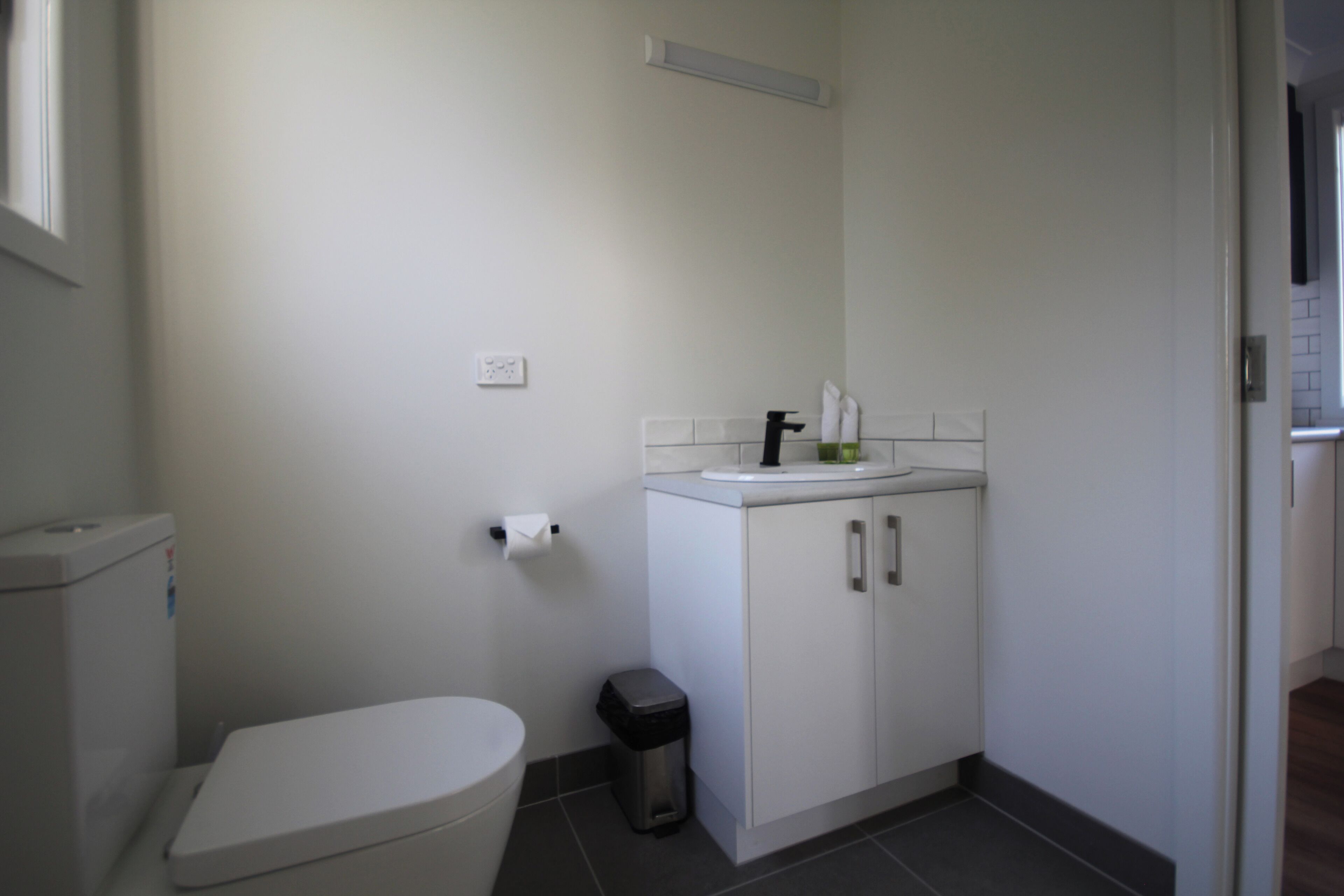 Un baño pequeño y limpio con inodoro, lavabo y armario.